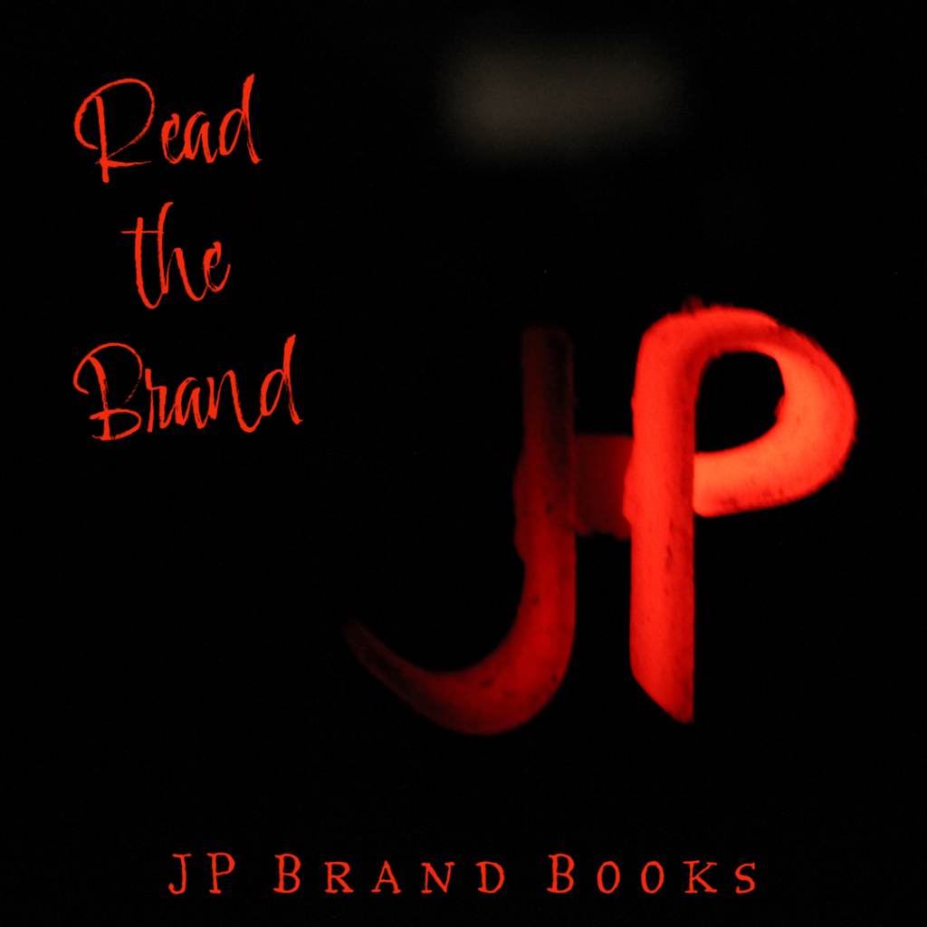 JP Branding iron glowing red on a black background.