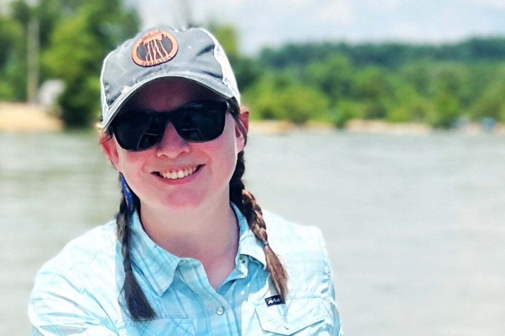 smiling woman in front of river shot